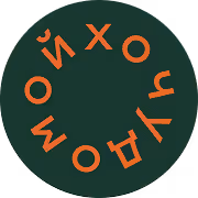 Круглый темно-зеленый значок с оранжевыми русскими буквами, расположенными по окружности.